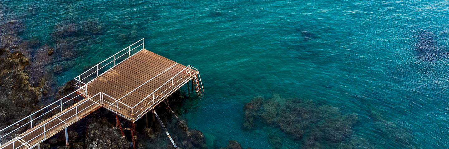 aerial drone shot van een pier met blauwhelder water